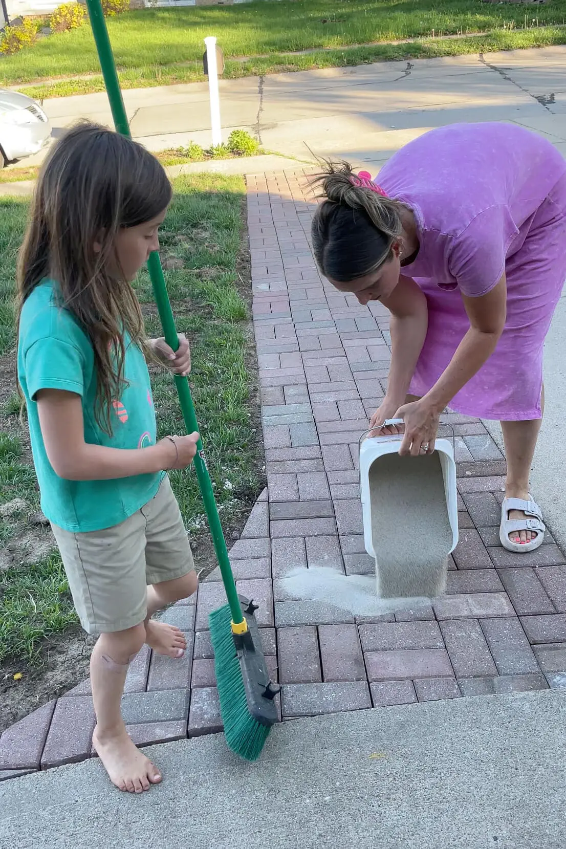 Using polymer sand to finish a paver driveway extension.